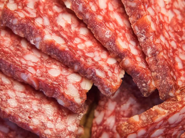 Smoked sausage, full frame. Pieces of appetizing meat snack close-up. Sliced sausage as background, meat