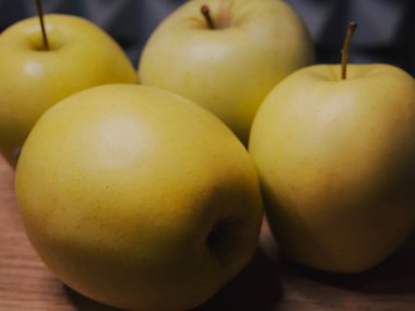 Dört büyük elma, yakın plan. Ahşap bir yüzeyde meyve..