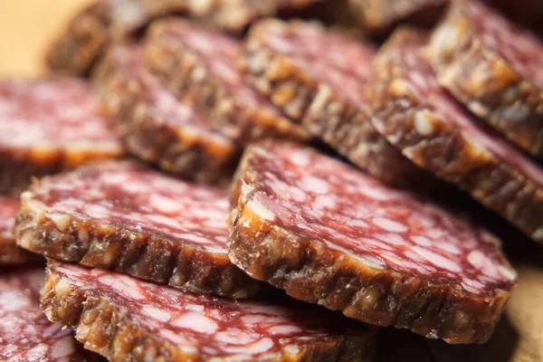Chunks of dried sausage taken in close-up. Sausage full frame. Delicious meat appetizer.