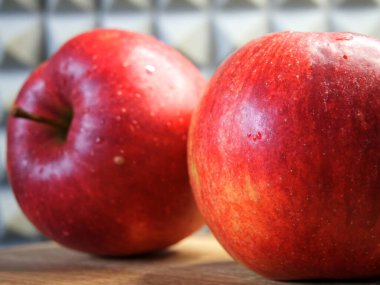 Ahşap bir yüzeyde iki büyük kırmızı elma. Olgun meyve. Gala elmaları.