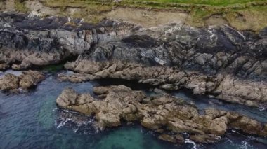 Beautiful Atlantic Ocean coast in County Cork, Ireland. Sea waves hit the coastal rocks, white sea foam, picturesque place.