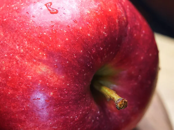 Big ripe red apple, macro shot. Drops of water on an apple peel. A beautiful fruit.