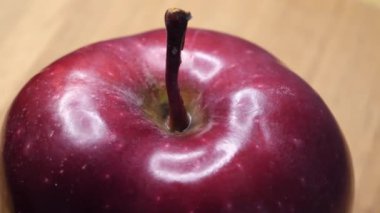 Single red apple close-up. An apple of the red chief variety. Highlights on the apple peel. Highly detailed video. Delicious fruit.
