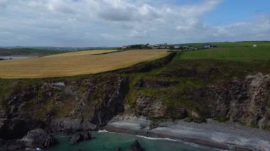 Farm fields on the rocky coast of the Celtic Sea. Landscape of the South of Ireland, West Cork. Picturesque rocks on a sunny day, the nature of Ireland. The area near Clonakilty.