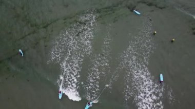 West Cork, Ireland, July 3, 2022. Novice surfers unsuccessfully try to ride a wave and fall into the water. Water sports, surfing. Beach holidays in the Nordic countries.