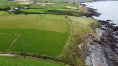 Green fields on the rocky coast of Ireland top view. Agrarian Irish landscape. The coast of the Atlantic Ocean.