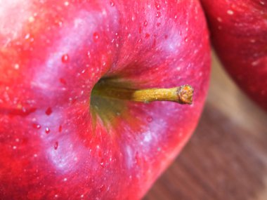 Big ripe red apple, closeup shot. Drops of water on an apple peel.