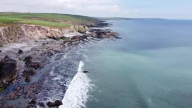 Green grass covered hills on the coast of Ireland. Rocks on the Atlantic Ocean. A picturesque seascape. Beautiful nature.