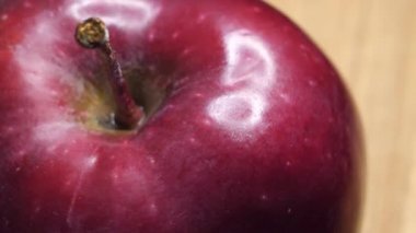 Highlights on the apple peel. One red apple, close-up video.