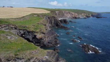 Farm fields on the coast of the Celtic Sea. Landscape of the South of Ireland, West Cork. Picturesque rocks on a sunny day, the nature of Ireland. The area near Clonakilty.