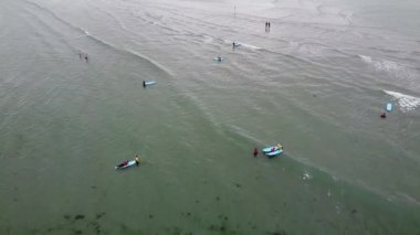 West Cork, Ireland, July 3, 2022. Surfing instructors teach beginners. People with surfboards, sea. Tourists are engaged in water sports. Beach holidays in the Nordic countries.