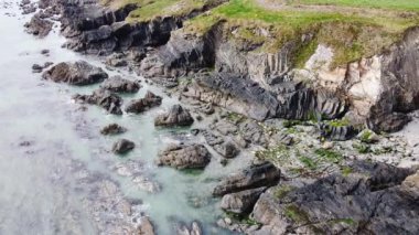 Drone view of the rocky coastline of the Celtic Sea. Sea waves are rushing on the stone shore. Seascape.