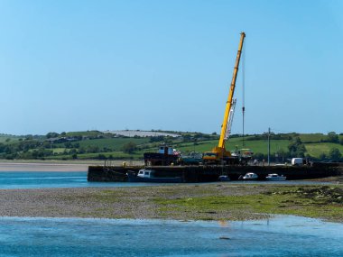West Cork, May 28, 2022. A small marina for fishing boats and a large crane. Seaside landscape on a sunny spring day.