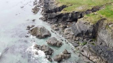 Sea waves roll on the rocks. Sea foam. Picturesque seashore.