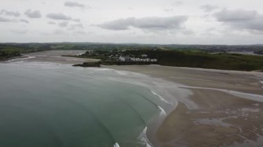 A view of the Cape of the Virgin Mary on a cloudy day. The coast of southern Ireland near the town of Clonakilty. The picturesque sandy beach of Inchydoney. Cloudy sky.