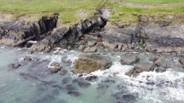Beautiful Atlantic Ocean coast in County Cork, Ireland. Sea waves hit the coastal rocks, white sea foam. A picturesque place.