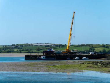 West Cork, 28 Mayıs 2022. Balıkçı tekneleri ve büyük bir vinç için bir marina. Güneşli bir bahar gününde deniz manzarası.