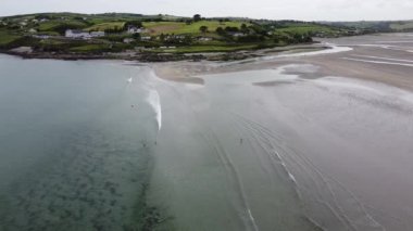 İrlanda 'nın güneyindeki Clonakilty kasabası yakınlarında büyük kumlu bir plaj. Resimli Avrupa deniz manzarası. Clonakilty Körfezi sular çekildiğinde. Yeşil sahil tepeleri. Güzel İrlanda plajı.