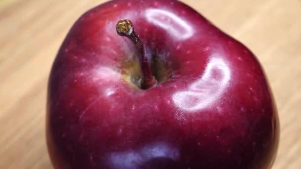 シングルアップルのクローズアップ 赤いチーフ品種のリンゴ リンゴの皮のハイライト 非常に詳細なビデオ おいしい果物 — ストック動画