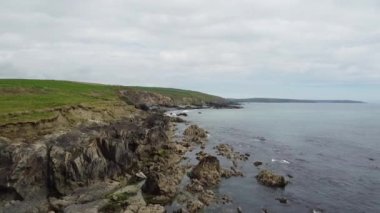 İrlanda kıyısındaki yeşil çim tepeleri. Atlantik Okyanusu 'ndaki kayalar. Resimli bir deniz manzarası. Güzel doğa..
