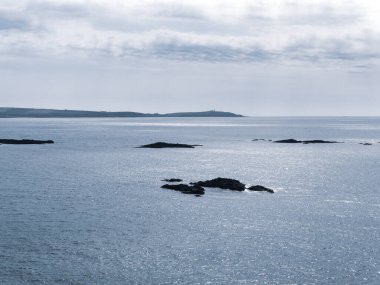 Atlantik Okyanusu 'nun soğuk suları arasındaki kayalar. Deniz Burnu. Kuzey Avrupa 'da, İrlanda' da soğuk bahar. Bulutlu havada Kelt Denizi. Deniz manzarası. Gökyüzünün altında mavi deniz