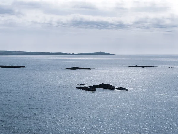 Atlantik Okyanusu 'nun soğuk suları arasındaki kayalar. Deniz Burnu. Kuzey Avrupa 'da, İrlanda' da soğuk bahar. Bulutlu havada Kelt Denizi. Deniz manzarası. Gökyüzünün altında mavi deniz