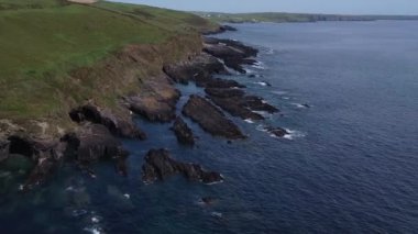 Kıyıdaki siyah kayalar. Güzel deniz manzarası. İrlanda 'nın deniz kıyısında. Atlantik 'in mavi suları, hava görüntüleri..