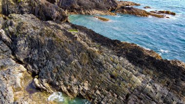 Sakin deniz yüzeyi ve kayalık kıyı. Kıyı manzarası, üst manzara. Hava fotoğrafı.