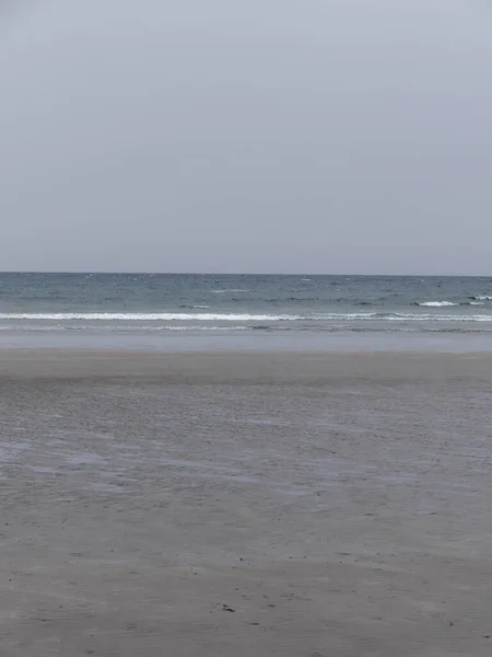 低潮时的海滨 凉爽的天气里 湿湿的沙滩 简约的海景 多云的凉爽天气 — 图库照片