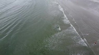 West Cork, İrlanda, 3 Temmuz 2022. Atlantik Okyanusu 'nun ıssız kumlu sahillerinde turistler, manzaranın tepesinde. Gelgit dalgaları ve büyük bir sahil..