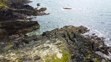 Sahilin taş pelerini. Güneşli havada kayalık deniz kıyısı. Avrupa 'nın Doğası.