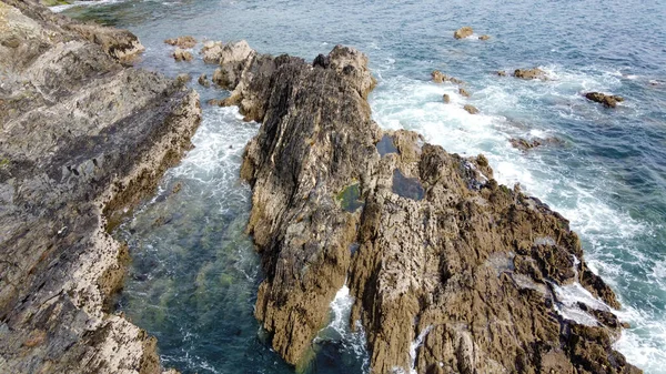 Atlantik Okyanusu 'nun güzel sahil kayalıkları. Deniz dalgalarında beyaz köpük. Deniz dalgaları arasında kayalar.