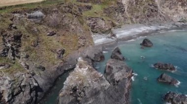 Kıyıdaki sarp kayalıklar. Güzel deniz manzarası. Helikopterden görüntü. Kıyı dalgaları, sörf.
