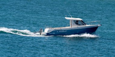 County Cork, İrlanda, 28 Mayıs 2022. Yüksek hızlı bir motorlu tekne güneşli bir bahar gününde denizde yelken açar. Su yüzeyinde bir tekne, deniz manzarası. Beyaz motorlu tekne