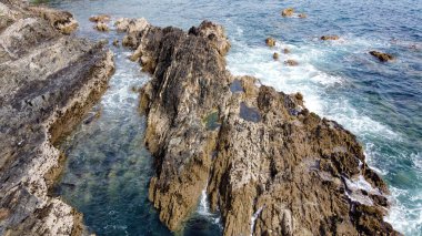 Atlantik Okyanusu 'nun güzel kayalıkları. Deniz dalgalarında beyaz köpük. Deniz dalgaları arasında kayalar.