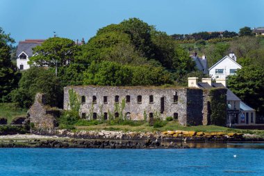 County Cork, İrlanda, 28 Mayıs 2022. Güneşli bir bahar gününde Clonakilty Körfezi kıyısındaki tahıl ambarının kalıntıları. İrlanda manzarası. Clonakilty yakınlarındaki Arundel Tahıl Dükkanı 'nın kalıntıları.