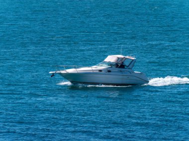 County Cork, İrlanda, 28 Mayıs 2022. Güneşli bir günde yüksek hızlı bir tekne denizde yelken açar. Su yüzeyinde bir tekne, deniz manzarası. Denizde beyaz motorlu tekne