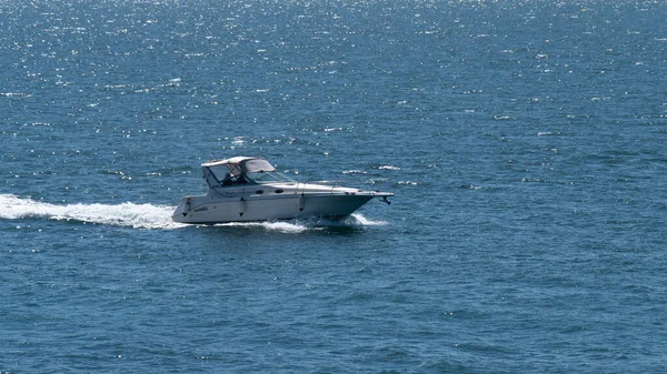 County Cork, İrlanda, 28 Mayıs 2022. Güneşli bir bahar gününde yüksek hızlı bir tekne denizde yelken açar. Su yüzeyinde bir tekne, deniz manzarası. Denizde beyaz motorlu tekne