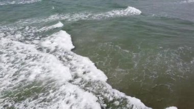 Atlantik Okyanusu 'nun köpüren soğuk dalgaları, üst manzara. Suyun yüzeyinde beyaz deniz köpüğü, insansız hava aracı videosu. Deniz manzarası, sadece su..