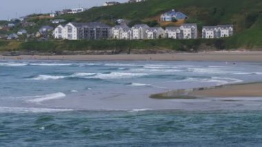 County Cork, İrlanda, Temmuz 2022. Inchydoney 'nin ünlü kumlu sahilindeki insanlar güneşli bir yaz gününde. Güzel deniz suyu, gel-git dalgaları. Deniz kenarındaki İrlanda manzarası.