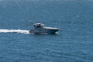 County Cork, İrlanda, 28 Mayıs 2022. Yüksek hızlı bir motorlu tekne güneşli bir bahar gününde denizde yelken açar. Su yüzeyinde bir tekne, deniz manzarası. Denizde beyaz motorlu tekne