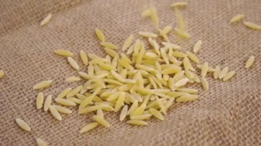 Soyulmuş kuru arpa kaba bir çuvala düşüyor. Makro. Ağır çekim. Kırsal gıda konsepti