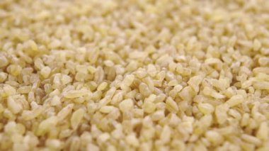 Bulgur taneleri yavaş çekimde yığılır. Makro. Döndürme