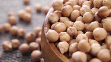 Bir kase dolusu pişmemiş nohut. Ağır çekimde kuru garbanzo düşüşü. Makro