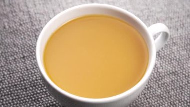 Beyaz bir fincan portakallı taze sıkılmış şeftali suyu. Yavaş çekimde düşüş. Kapatın. Döndürme