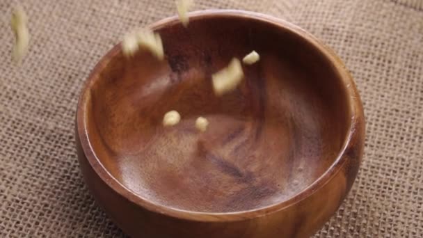 日常饮食中的干大豆片落在木制的天然碗中 缓慢地运动在粗糙的粗布上 食物类似物肉代用品的概念 靠近点轮调 — 图库视频影像