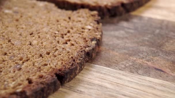 将新鲜的全麦黑麦黑麦有机面包切成片 并配以面包皮 多莉开枪了谷物健康膳食纤维早餐 在木制的背景上 — 图库视频影像