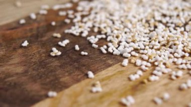 Amaranth kırsal bir ahşap yüzeyde patlamış ve tahılları şişirmiş. Pseudocereal yiyecek, glütensiz. Makro. Dolly vurdu.