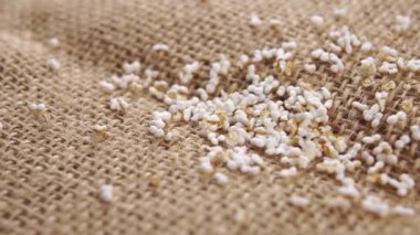 Kırsal bir çuval bezi üzerinde patlamış tahıllar. Pseudocereal yiyecek, glütensiz. Makro. Dolly vurdu.