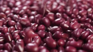 Kuru kırmızı fasulye. Ağır çekimde bir yığın üzerine düşmek. Makro. Dolly vurdu. Pişmemiş organik baklagiller. Vigna angularis